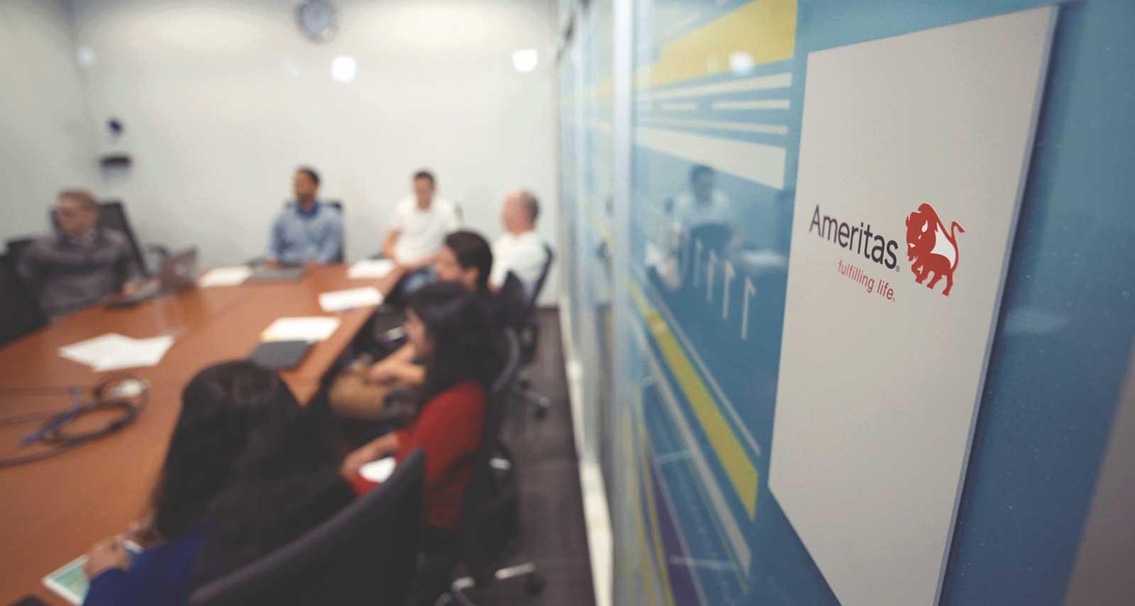 Image of employees meeting in board room.