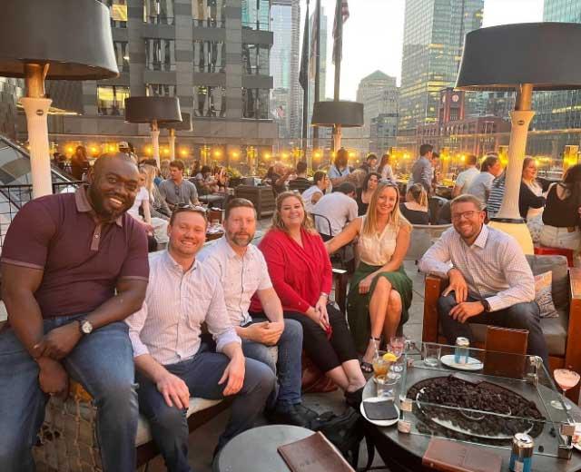group of people gathering at a table outside
