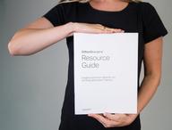Person holding CliftonStrengths Resource Guide.