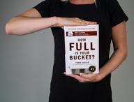 Person holding How Full Is Your Bucket? Expanded Anniversary Edition.