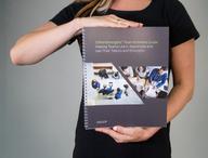 Person holding CliftonStrengths Team Activities Guide.